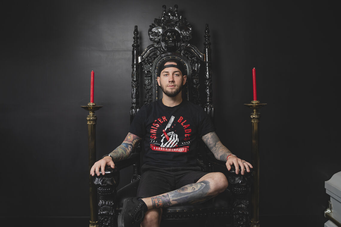 Photo: Chris Taylor, owner sits in his throne at Sinister Blades | Photo Credit: Max Grudzinski