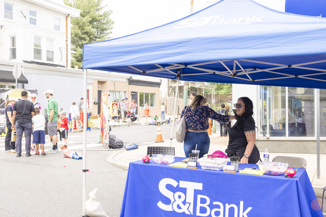 Photo: S & T Bank, a sponsor of the festival, set up a booth in front of their business. Photo Credit | Studio Luminoso by Christy McMahon
